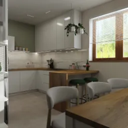 Jasna kuchnia z drewnianym blatem i stołem, zielone jabłka w białej misie na stole, rolety w oknie, rośliny doniczkowe wiszące nad blatem, minimalistyczny design.