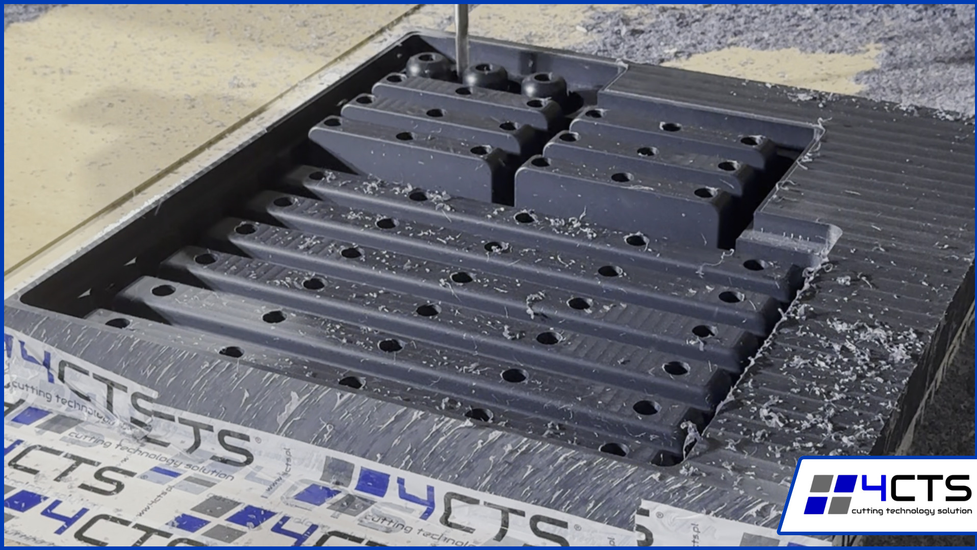 Precyzyjna obróbka CNC tworzy formę z otworami, wióry na powierzchni. Wiertło w akcji, detale obróbki, szary materiał.