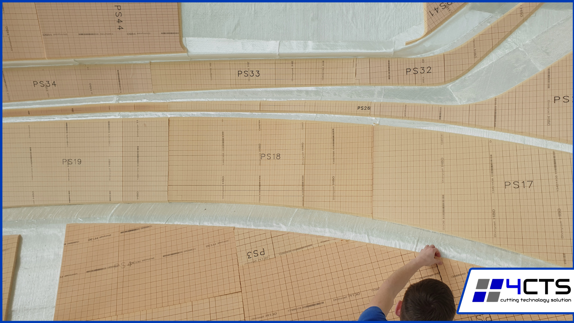 Formy z siatką i oznaczeniami PS do obróbki, ułożone na białym podłożu. Widoczna dłoń dopasowująca element. Logo firmy w prawym dolnym rogu.