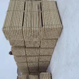 R&oacute;wnomiernie ułożone i spięte metalową taśmą paczki z suchym drewnem na placu składowym, widok z g&oacute;ry.