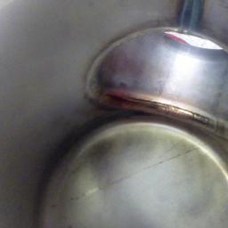 Kamet - Wewnętrzne ujęcie spawu na metalowej konstrukcji, widoczne ślady obróbki i nierówności spoiny.