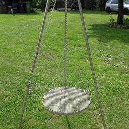 Kamet - Metalowy trójnóg z rusztem wiszącym na łańcuchach, ustawiony na trawniku w ogrodzie.