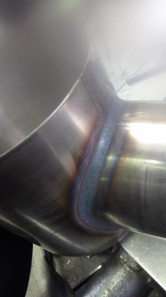 Szczegółowe ujęcie spawu łączącego dwie rury ze stali nierdzewnej, widoczne ślady ciepła i precyzyjne wykonanie spoiny.