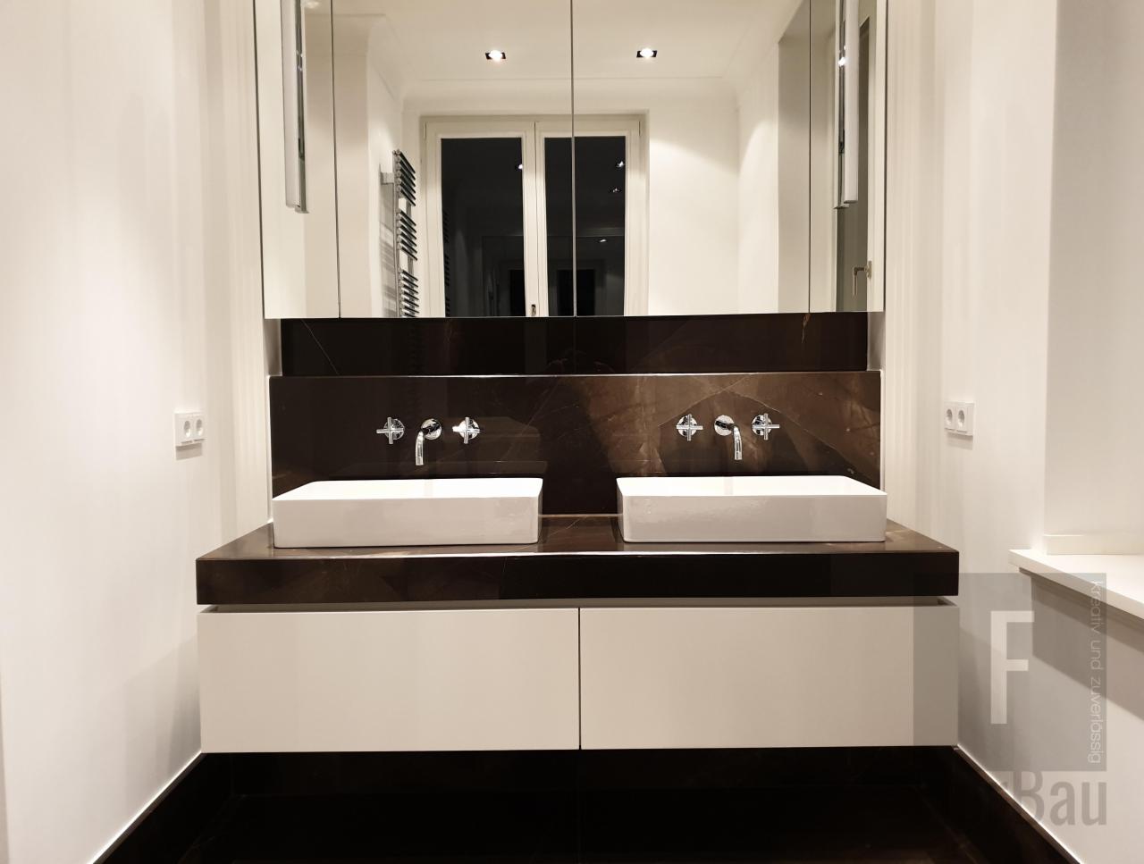 Nowoczesna łazienka z dwoma prostokątnymi umywalkami nablatowymi, chromowaną armaturą, ciemnobrązowym blatem i białymi szafkami pod umywalkami, duże lustro na ścianie.