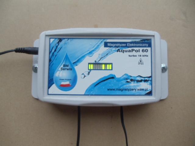Elektroniczny magnetyzer wody AquaPol 60 w obudowie, z podłączonym zasilaniem, wyświetlający poziom pracy na pasku LED, z widocznym logo firmy BM Serwis i adresem strony internetowej.