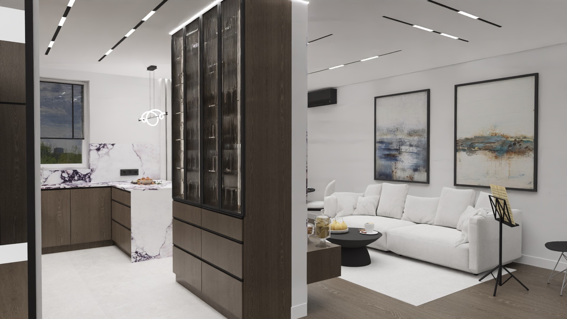 Nowoczesne wnętrze: kuchnia z marmurowym blatem i drewnianymi szafkami, oddzielona od salonu przeszkloną witryną z ciemnego drewna. W salonie biała sofa i abstrakcyjne obrazy.