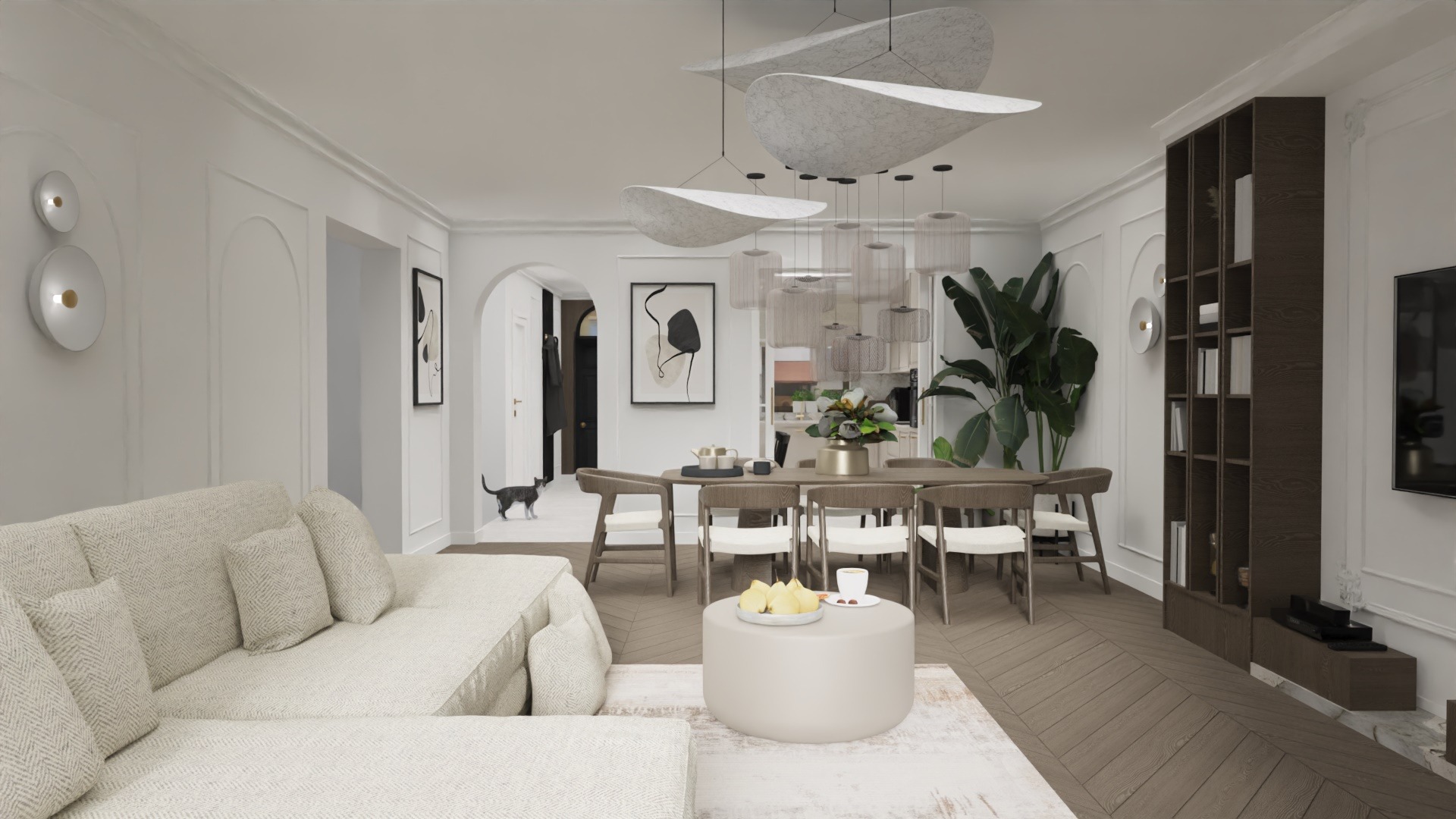 Jasne, przestronne wnętrze mieszkania z sofą w odcieniach beżu, stołem jadalnym z krzesłami, oryginalnym oświetleniem i dekoracyjnym regałem na książki; w tle widoczny kot.