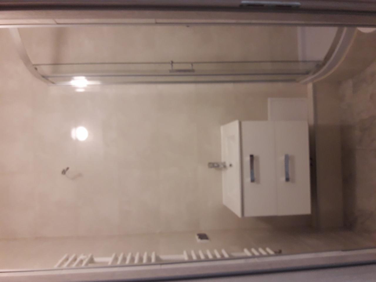 Wykończona łazienka w Łaziskach Górnych z kabiną prysznicową i białą szafką pod umywalką, widoczne płytki na ścianach i podłodze.