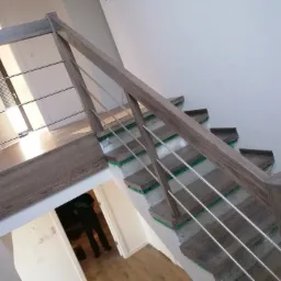 Montaż schodów z drewnianymi stopniami i metalowymi barierkami w Dobrzycy, widoczne niedokończone wykończenie ściany.