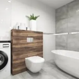 Nowoczesna łazienka z białą wanną wolnostojącą, pralką obok zabudowy z drewnianymi panelami, na której zamontowano wiszącą toaletę. Minimalistyczne płytki w odcieniach bieli i szarości, oświetlenie...