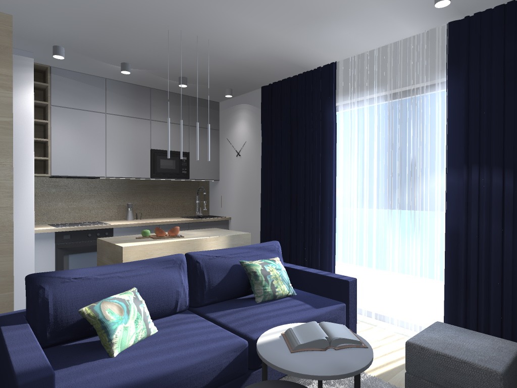 Nowoczesny salon z otwartą kuchnią, granatowa sofa z poduszkami w odcieniach zieleni, okrągły stolik z książką, minimalistyczne lampy wiszące nad wyspą kuchenną, zasłony w kolorze granatowym i białym.