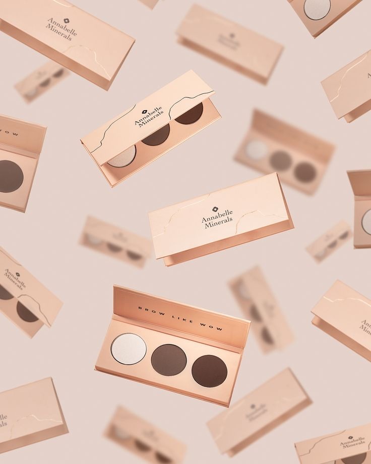 Lekko różowe palety cieni Annabelle Minerals unoszą się w powietrzu, tworząc dynamiczną kompozycję. Widoczne trzy odcienie w otwartej palecie.