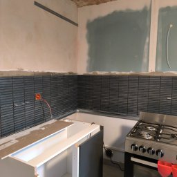 fliesen-tech - Montaż mozaiki w kuchni, widoczna instalacja elektryczna i fragment zabudowy kuchennej. Stare ceglane sklepienie nadaje wnętrzu unikalny charakter.