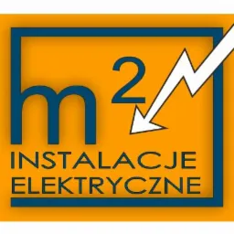 Logo firmy z niebieskim napisem 'm2' i 'INSTALACJE ELEKTRYCZNE' w kwadratowej ramce na pomarańczowym tle, z symbolem błyskawicy.