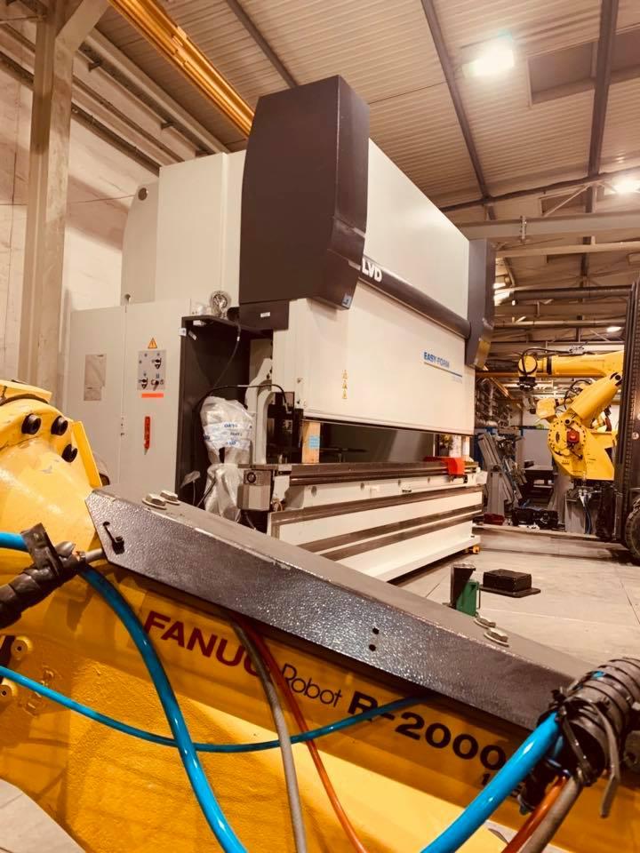 Żółty robot przemysłowy Fanuc Robot R-2000A w hali produkcyjnej, częściowo zasłaniający dużą, białą prasę krawędziową LVD Easy-Form.