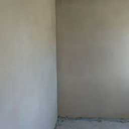 Surowe wnętrze pokoju po nałożeniu tynku, z widocznymi nierównościami i surowym betonem na podłodze, w oczekiwaniu na dalsze prace wykończeniowe.