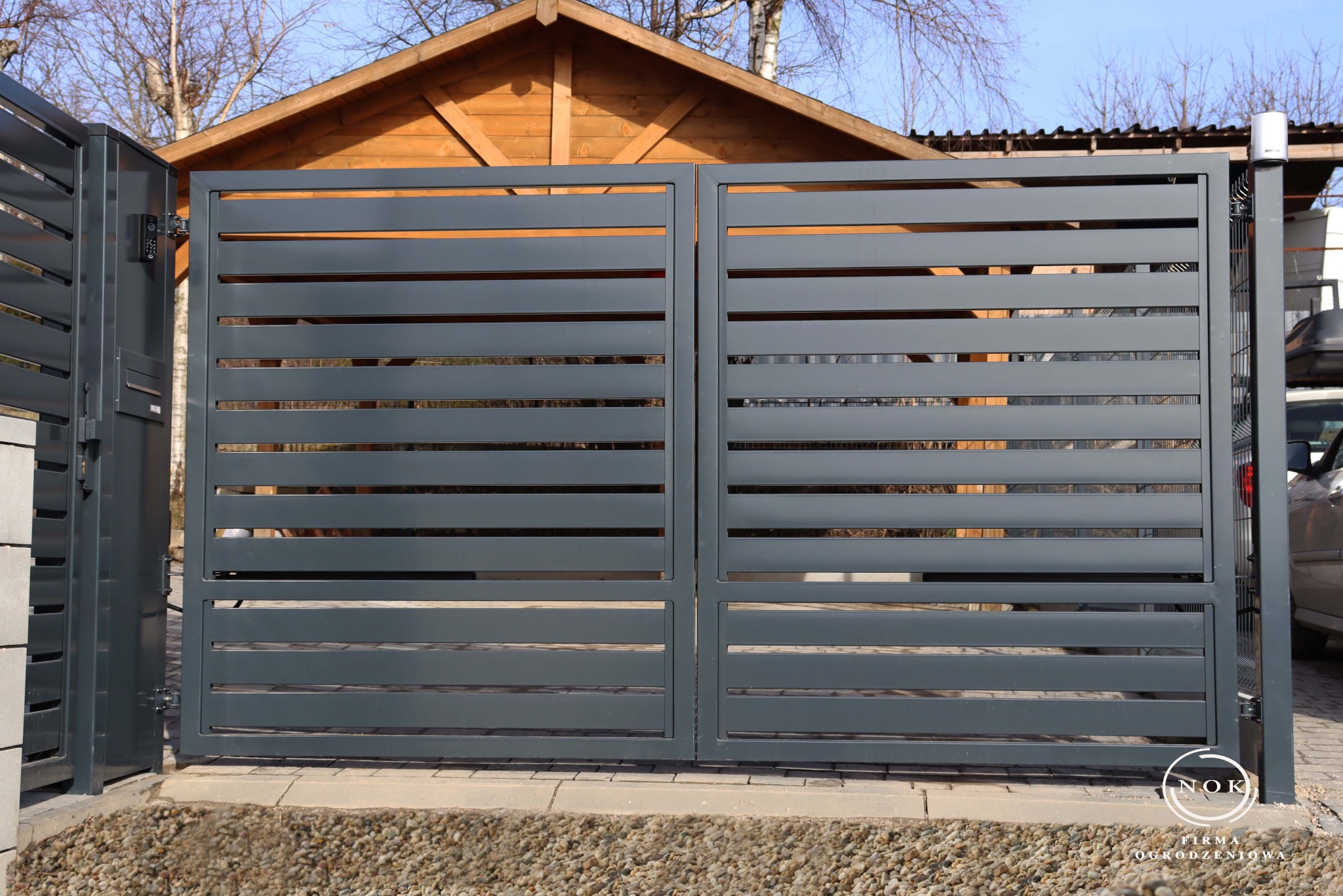 Brama dwuskrzydłowa palisadowa pod wymiar, z profili 10x2 cm, prześwit 2,5 cm. Kolor grafit RAL7016.