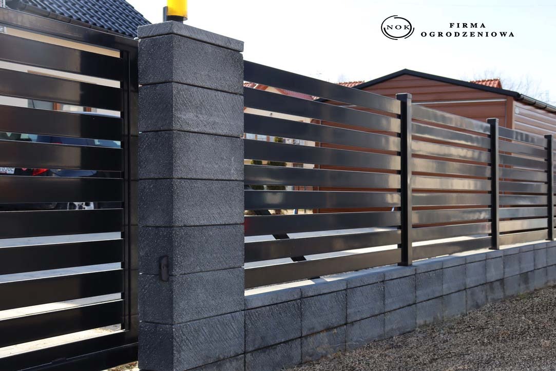 Nowoczesne ogrodzenie palisadowe z bloczków Roma Perfect w kolorze morion i czarnych przęseł (profile 10x2 cm, prześwit 2,5 cm) RAL9005, widok z bliska.