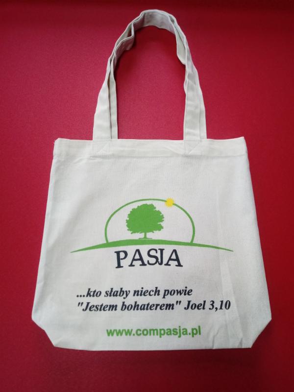 Torba bawełniana z nadrukiem logo firmy 'PASJA' na czerwonym tle.