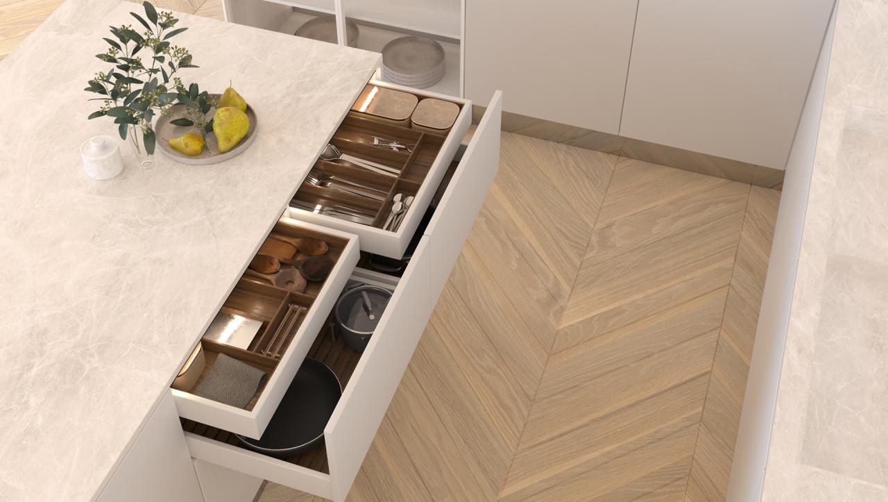 Nowoczesna kuchnia z otwartymi szufladami prezentującymi drewniane organizery na sztućce, przybory kuchenne i garnki, na blacie marmurowy wazon z gruszkami, podłoga z parkietu ułożonego w jodełkę.