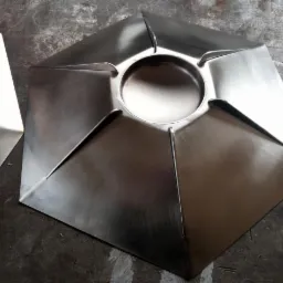 Elementy konstrukcyjne ze stali nierdzewnej, z centralnym otworem, ułożone na szorstkiej, metalowej powierzchni.