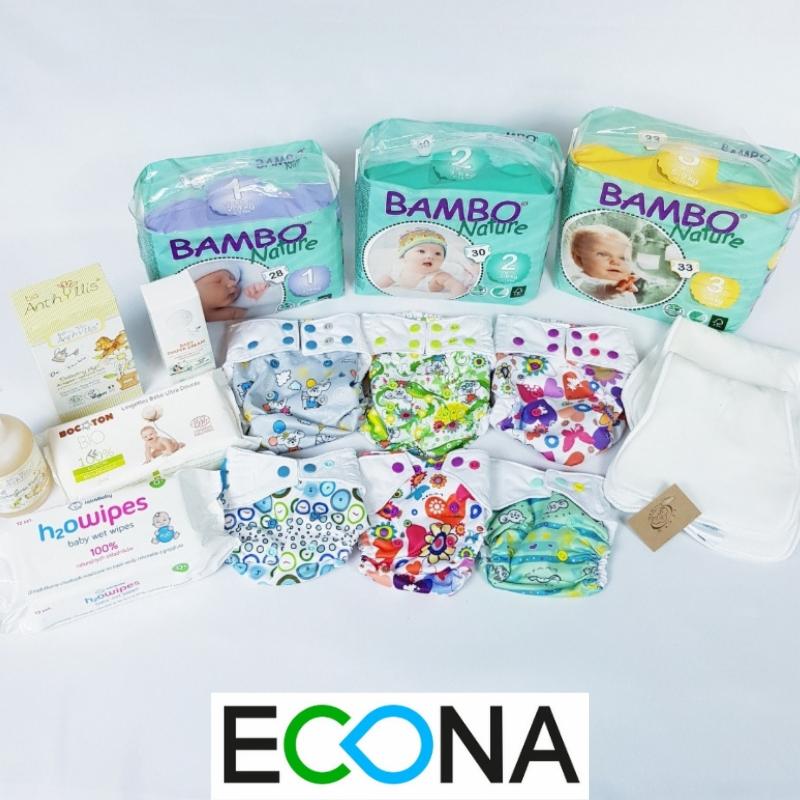 Zestaw ekologicznych pieluch wielorazowych i akcesoriów do pielęgnacji niemowląt, w tym pieluchy Bambo Nature w opakowaniach z numerami 1, 2 i 3, chusteczki nawilżane i inne produkty na białym tle...