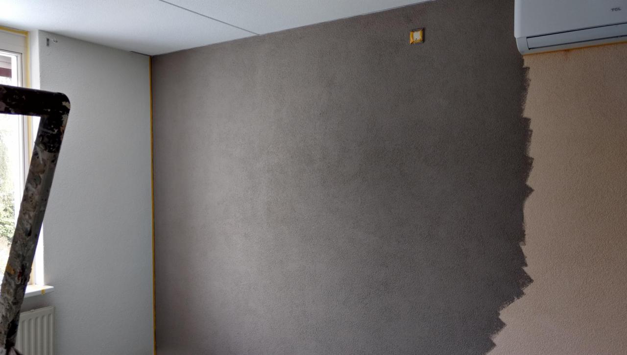 Ściana w trakcie malowania na dwa kolory: szary i beżowy, widoczna drabina malarska przy oknie, zaklejone taśmą narożniki, klimatyzator TCL na ścianie.