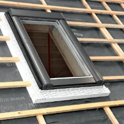 Montaż okna dachowego z roletą zewnętrzną w konstrukcji dachu pokrytego membraną izolacyjną.