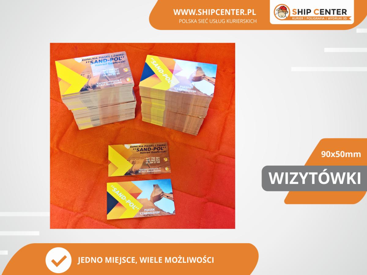 Stos wizytówek firmy 'SAND-POL' z motywem koparki i piasku na pomarańczowym tle, obok pojedyncza wizytówka z widocznymi danymi kontaktowymi i logo firmy.