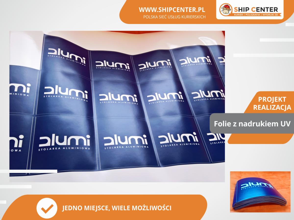 Arkusze folii z powtarzalnym niebieskim nadrukiem logo 'alumi STOLARKA ALUMINIOWA' wykonanym w technologii UV, prezentowane jako projekt zrealizowany.