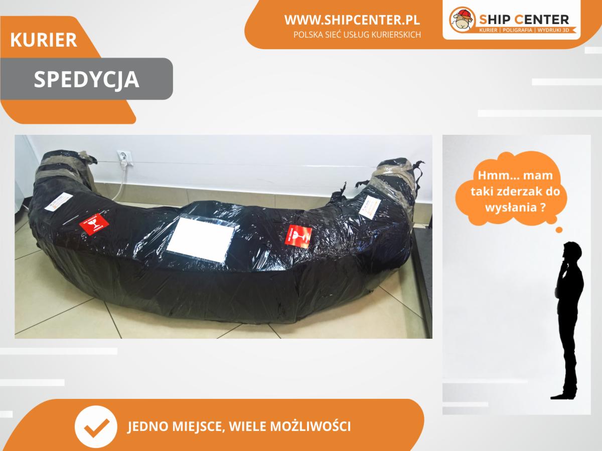 Zapakowany w czarną folię zderzak samochodowy, przygotowany do wysyłki przez firmę kurierską Ship Center, z logiem firmy widocznym w tle.