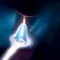 Zbliżenie na proces spawania: intensywny łuk elektryczny, otoczony niebieską poświatą, topi metal na ciemnym, metalicznym tle.