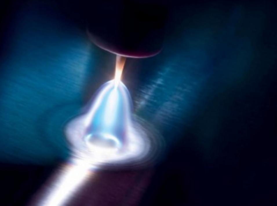 Zbliżenie na proces spawania: intensywny łuk elektryczny, otoczony niebieską poświatą, topi metal na ciemnym, metalicznym tle.