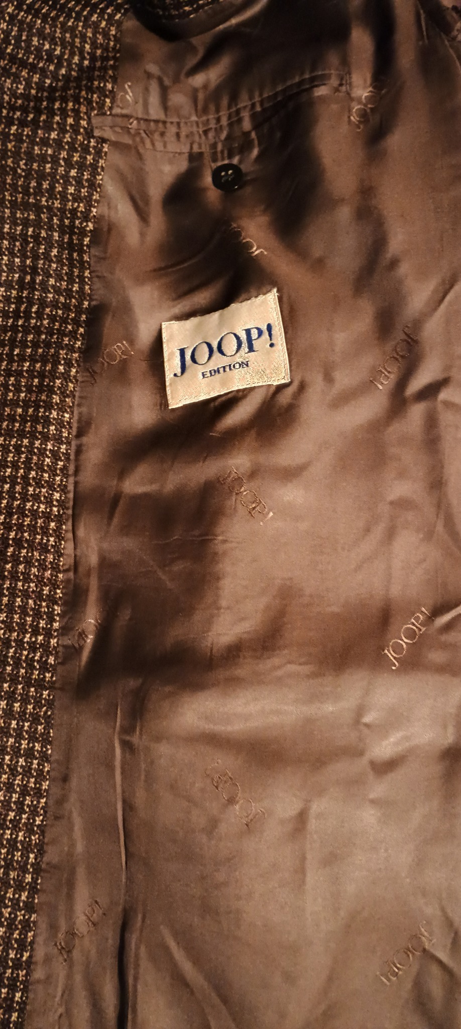 Wnętrze używanej marynarki w brązowym kolorze z widocznym logo Joop! Edition na metce i powtarzającym się logo Joop! na podszewce.