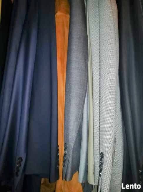 Rząd marynarek w różnych kolorach i wzorach wiszących blisko siebie, widoczne guziki przy mankietach.