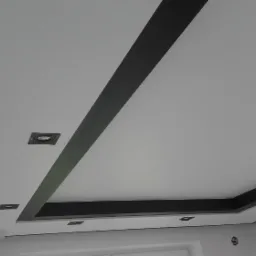 Biały sufit z czarnymi, geometrycznymi elementami dekoracyjnymi i wbudowanymi punktami świetlnymi.