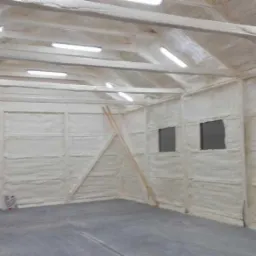 Wnętrze ocieplonego pianką PUR poddasza z widocznymi drewnianymi elementami konstrukcyjnymi i małymi oknami, oświetlone lampami LED.