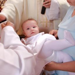 Borsuk - Ujęcie z uroczystości chrztu dziecka, z widocznym księdzem polewającym wodą główkę niemowlęcia, trzymanego przez matkę w jasnoniebieskiej sukience.