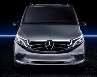 Przód szarego, elektrycznego vana Mercedes-Benz z podświetlanym grillem i reflektorami LED na ciemnym tle.