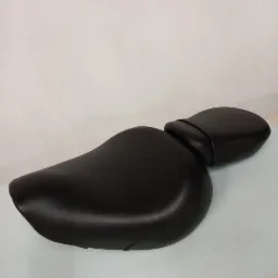 Czarne, skórzane siedzenie motocyklowe z oparciem, widoczne szwy i gładka powierzchnia, na jasnym tle.