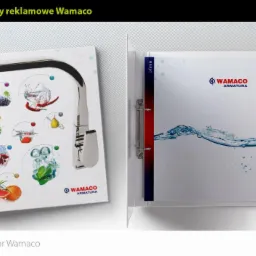 Otwarty segregator firmowy Wamaco z okładką przedstawiającą kran z grafikami owoców i warzyw w wodzie oraz logo firmy.