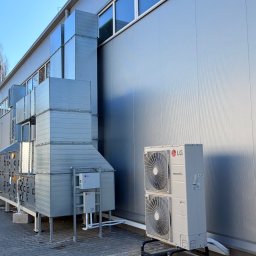 JAMRÓZ Nowoczesne Technologie - Instalacja klimatyzacji przemysłowej LG Multi V 8 na zewnątrz budynku. Widoczne jednostki zewnętrzne, kanały wentylacyjne i skrzynki sterownicze.