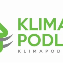 Zielone logo firmy Klima Podlasie z symbolem domu i falami powietrza, nazwa firmy w kolorze zielonym, adres strony internetowej pod nazwą.