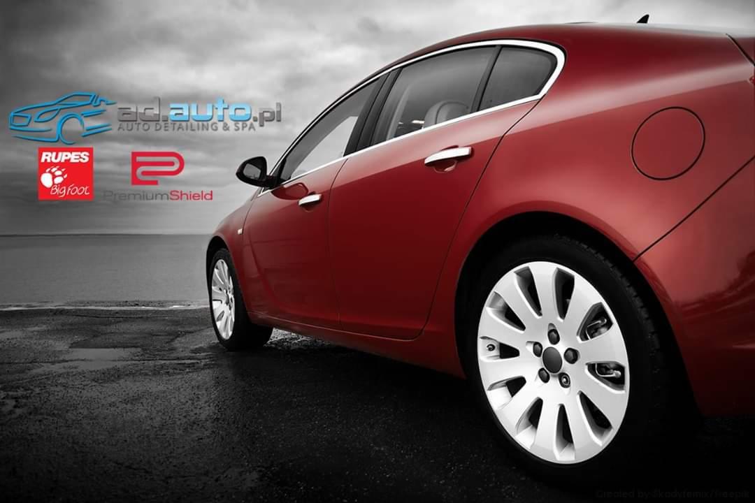 Czerwony samochód osobowy po detailingu, widoczne logo ad.auto.pl, Rupes BigFoot i PremiumShield na tle czarno-białego krajobrazu.