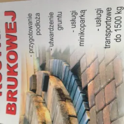 Ujęcie z bliska ulotki reklamowej firmy brukarskiej z informacją o układaniu kostki, przygotowaniu podłoża, utwardzaniu gruntu, usługach minikoparką i transporcie do 1500 kg, widoczne ułożone...