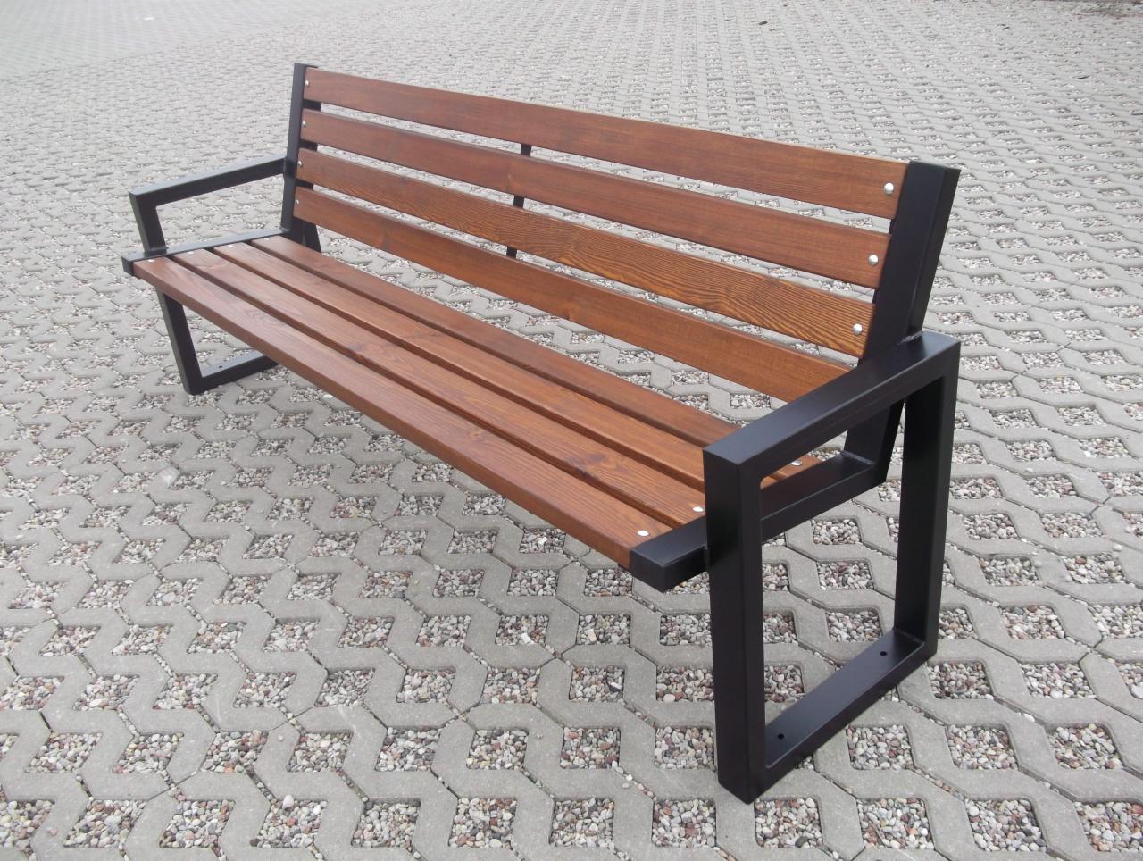 Ławka parkowa z drewnianymi listwami i czarną, metalową konstrukcją, umieszczona na brukowanej powierzchni.