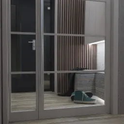 Nowoczesne wejście do domu z przeszklonymi drzwiami, widoczne buty i garderoba w neutralnych kolorach, oświetlenie LED.