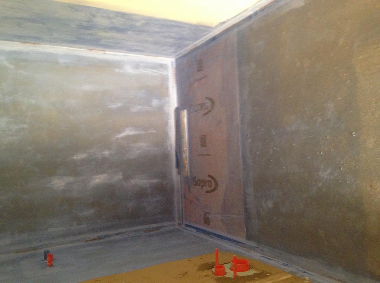 Przygotowana do hydroizolacji ściana w narożniku łazienki z widocznym zabezpieczeniem folią w płynie marki Sopro oraz akcesoriami do uszczelniania.