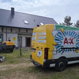 PRZEDSIĘBIORSTWO HANDLOWO USŁUGOWE Karolina WUZIEŃ - Budowa domu jednorodzinnego z betonomieszarką i pompą do wylewek. Na pierwszym planie firmowy van z napisem 'Posadzki anhydrytowe'.