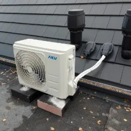 Zewnętrzna jednostka klimatyzacji MDV zamontowana na dachu pokrytym szarą dachówką, z widocznymi elementami wentylacyjnymi i przewodami.